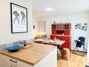 a kitchen with a table and a desk in a room at La perle suedoise - Studio avec terrasse et cour privée in Calais