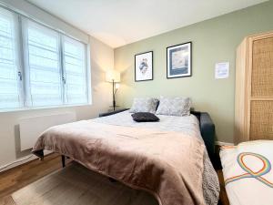 a bed in a room with a large window at La perle suedoise - Studio avec terrasse et cour privée in Calais