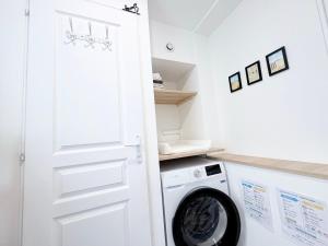 a laundry room with a washer and dryer at La perle suedoise - Studio avec terrasse et cour privée in Calais +35 photos