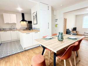 a kitchen and dining room with a wooden table and chairs at La perle suedoise - Studio avec terrasse et cour privée in Calais