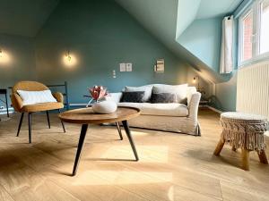 a living room with a couch and a table at Le CoqLoft in Coquelles