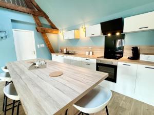 a kitchen with a wooden table and white cabinets at Le CoqLoft in Coquelles +23 photos