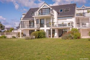 a large white house with a lawn in front of it at REF 321 - LARMOR PLAGE appartement type 3 vue mer in Larmor-Plage
