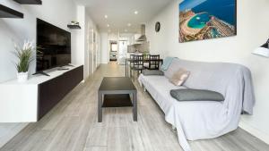 a living room with a white couch and a table at Guanarteme Vista Surf, Las Canteras in Las Palmas de Gran Canaria