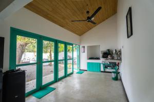 a living room with green doors and a ceiling fan at Villa Pigeon Paradise in Unawatuna