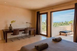 a bedroom with a table and a desk with a view at Villa Sirio in Cala de Bou +79 photos