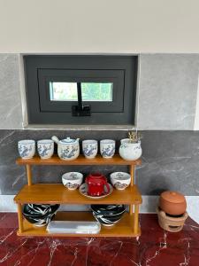 a shelf with cups and dishes on it at Tổ Nhím Homestay in Ấp Cái Chuối