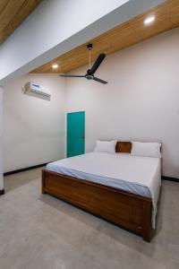 a bedroom with a bed with a green door at Villa Pigeon Paradise in Unawatuna