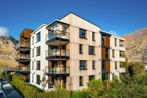an apartment building with balconies on the side of a street at Hygge Garden Apartment with Private Sauna in Queenstown