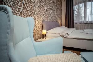 a room with two beds and a chair and a lamp at Relax & Luxury apartment in Veľká Lomnica +26 photos