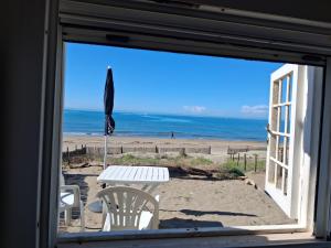 a view of the beach from a window with a table at CASINA SULLa SABBIA in Torvaianica