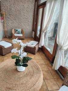 a room with a table with a vase of flowers on it at Maison de campagne in Le Puy