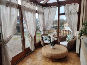 a screened in porch with a table and chairs at Maison de campagne in Le Puy