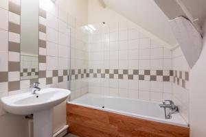 a bathroom with a sink and a bath tub at Pierres, cloches et vignes in Auxerre