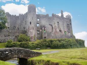 an old castle with a bridge in front of it at Pendine Beach Apartment in Pendine +2 photos