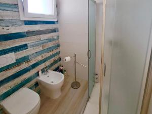 a bathroom with a toilet and a sink at Serene Sea - Holiday Homes in Marina di Pescoluse +39 photos