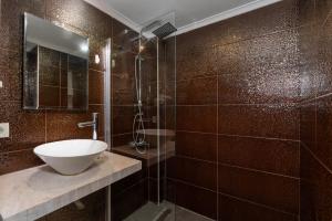 a brown tiled bathroom with a sink and a shower at Porto Azul Hotel Bodrum in Bodrum City +19 photos