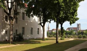 a white building with trees in front of it at Pierres, cloches et vignes in Auxerre