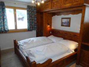 a large bed in a bedroom with a wooden frame at Apartment Weisshorn in Riederalp
