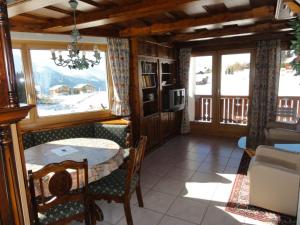 a dining room with a table and some windows at Apartment Weisshorn in Riederalp