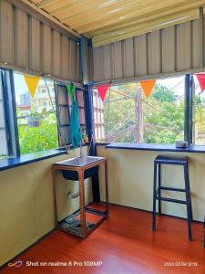 a room with a table and a stool and windows at Vanny's Peaceful Guesthouse in Phnom Penh