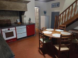 a kitchen with a table with chairs and a stove at Maison de campagne in Le Puy