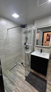 a bathroom with a sink and a glass shower at Luxury Apartments TRED in Pleven