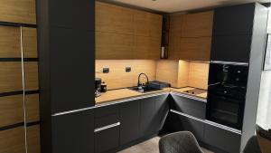 a kitchen with black cabinets and a sink at Luxury Apartments TRED in Pleven