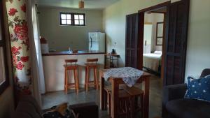 a living room with a kitchen with a table and chairs at Casinha nas montanhas in Gonçalves