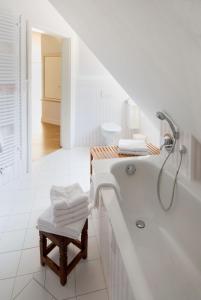 a white bathroom with a tub and a toilet at Clara Elisabeth in Döhnsdorf +37 photos