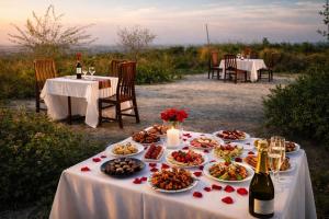 a table with plates of food and bottles of wine at Voyager's Center in Kikorongo