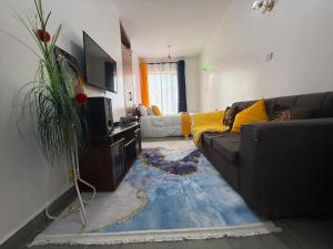 a living room with a couch and a tv at Shooting Stars Homes in Gatunga