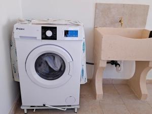 a washing machine in a bathroom next to a toilet at Serene Sea - Holiday Homes in Marina di Pescoluse