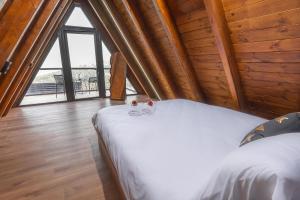 a bedroom with a bed and a large window at Wood & Soul - בקתות משולשות מיוחדות עם בריכה פרטית in ‘Isfiyā +42 photos