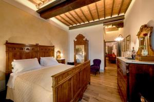 a bedroom with a large bed with a wooden dresser at Il Tosco in Montepulciano
