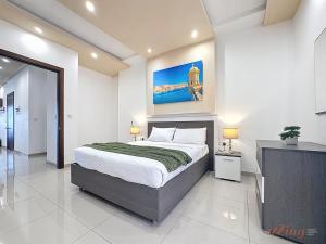 a bedroom with a bed and a painting on the wall at Elegant Seafront Duplex with Stunning Panoramic Views in Birżebbuġa