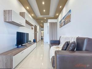 a living room with a tv and a couch at Elegant Seafront Duplex with Stunning Panoramic Views in Birżebbuġa
