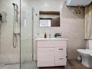 a bathroom with a shower and a sink and a toilet at Elegant Seafront Duplex with Stunning Panoramic Views in Birżebbuġa +11 photos