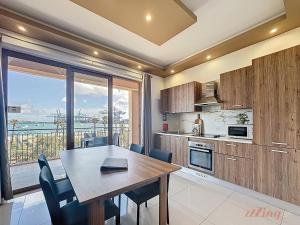 a kitchen with a dining table and a view of the ocean at Elegant Seafront Duplex with Stunning Panoramic Views in Birżebbuġa