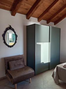 a bedroom with a chair and a mirror on the wall at Vento di Mare - Tramontana con piscina in Moneglia +15 photos