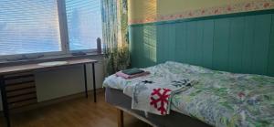 a bedroom with a bed and a desk and windows at Pankkikallio 14 in Sorsakoski