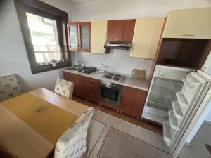 a kitchen with a wooden table and a kitchen with a refrigerator at Grand Panorama Apartment in Fojnica