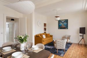 a living room with a table and a yellow couch at Ker Marlyne - Proche du Port in Dinard