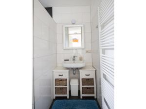 a white bathroom with a sink and a mirror at Christoffellaan 72 in Brouwershaven +9 photos