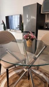 a glass table with a glass chair and a tv at The F402 Residence in Gaborone