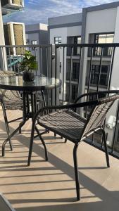 a table and a chair on a balcony at The F402 Residence in Gaborone
