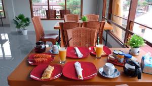 a table with red plates of food and drinks at Toraja Hikari Homestay in Rantepao