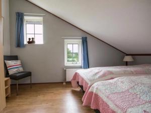 a bedroom with two beds and a chair and a window at Christoffellaan 72 in Brouwershaven