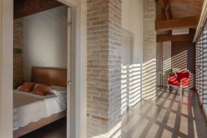 ein Schlafzimmer mit einem Bett und einer Ziegelwand in der Unterkunft Dimora Le Conce - Loft di Charme in Fabriano + 6 Fotos