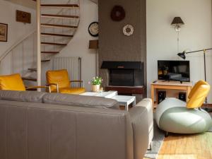 a living room with a gray couch and yellow chairs at Christoffellaan 72 in Brouwershaven